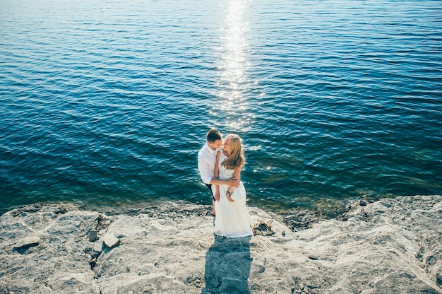 Casal jovem anda na praia arenosa