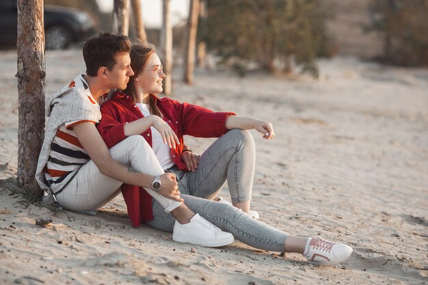 Casal jovem apaixonado no pôr do sol na praia. ame. homem e mulher abraçando no verão.