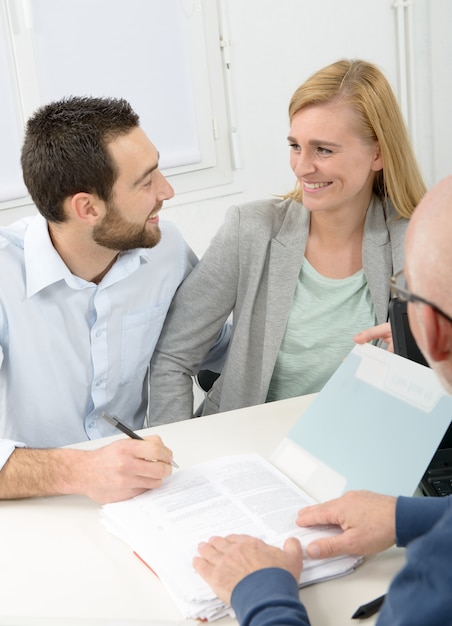 Casal jovem, assinando contrato de compra de propriedade