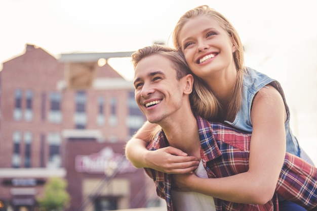 Casal jovem bonito está sorrindo enquanto caminhava ao ar livre