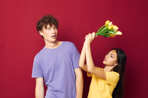 Casal jovem bonito um buquê de flores amarelas com base em amizade inalterada