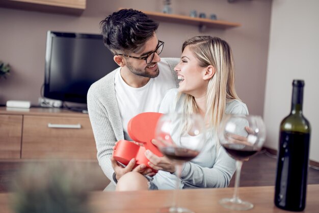 Casal jovem com presente em casa