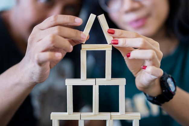 Casal jovem construindo uma casa de blocos