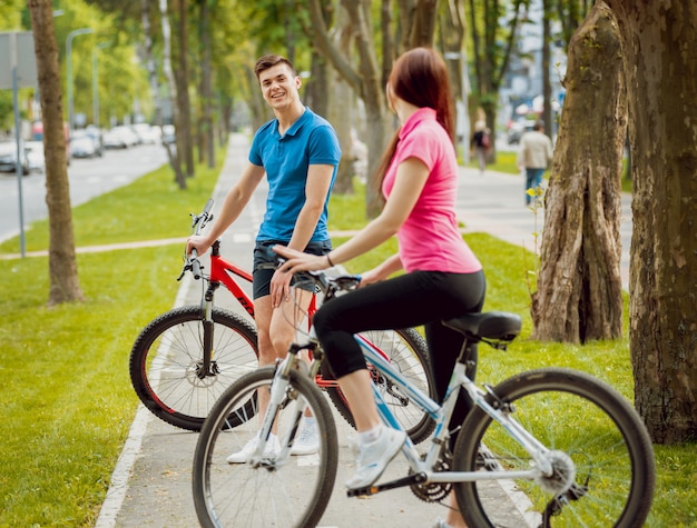 Casal jovem de bicicleta.