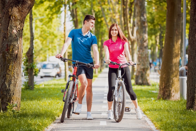 Casal jovem de bicicleta.