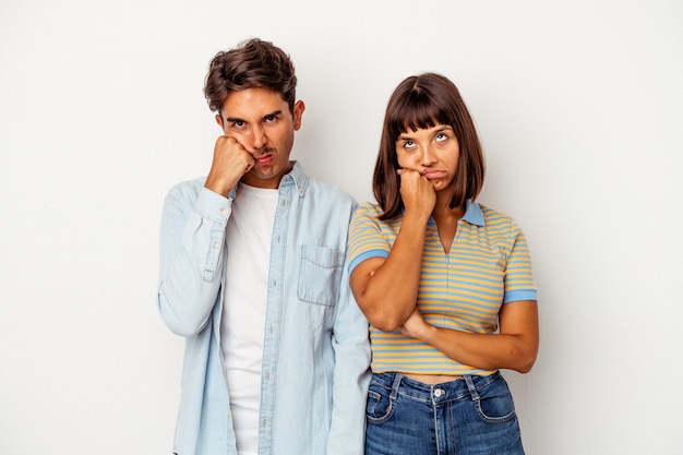 Casal jovem de raça mista, isolado no fundo branco, que se sente triste e pensativo, olhando para o espaço da cópia.