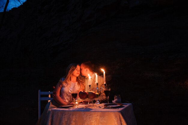 Casal jovem desfrutando de um jantar romântico à luz de velas, ao ar livre