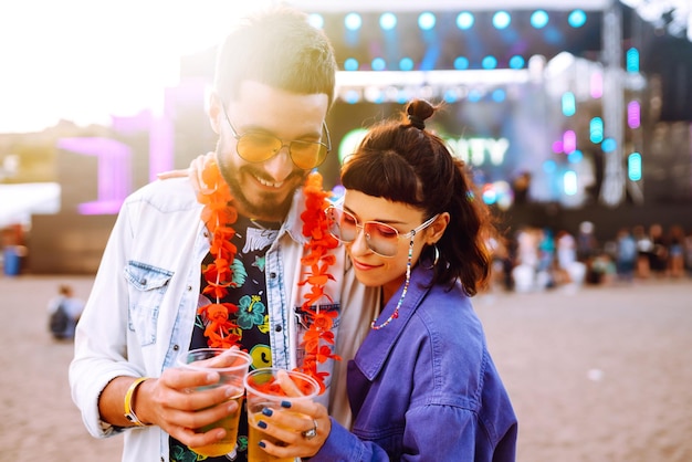 Casal jovem e alegre no festival de música Amigos felizes bebendo cerveja e se divertindo