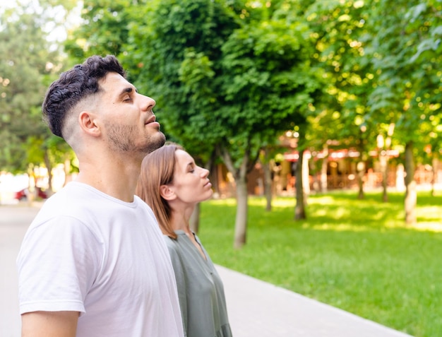 Casal jovem e atraente respirando e meditando com os olhos fechados Rituais matinais