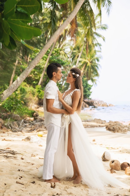 Casal jovem e bonito está comemorando casamento na praia