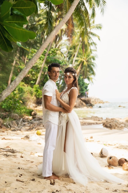 Casal jovem e bonito está comemorando casamento na praia