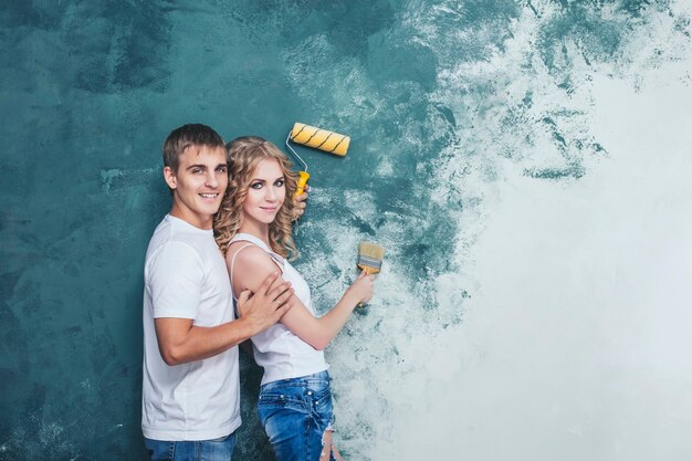 Casal jovem e bonito fazendo reformas em uma casa nova, jovem família feliz