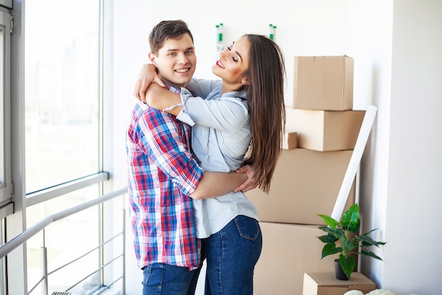 Foto casal jovem e engraçado curtindo e comemorando a mudança para uma nova casa