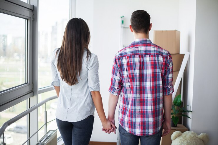 Foto casal jovem e engraçado curtindo e comemorando a mudança para uma nova casa