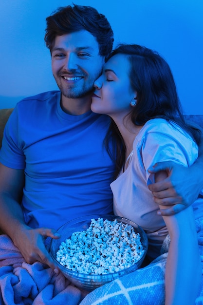Foto casal jovem e feliz comendo pipoca e assistindo filme