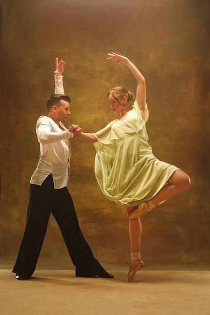 Casal jovem e flexível de dança moderna posando em estúdio