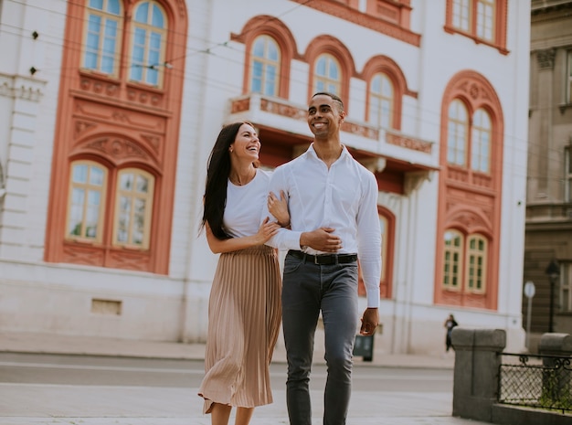 Casal jovem e multiétnico bonito andando na rua