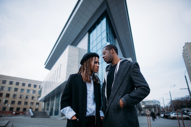 Casal jovem elegante. Juventude afro-americana em pano de fundo urbano. Modelos elegantes na rua, fundo do céu, conceito de beleza