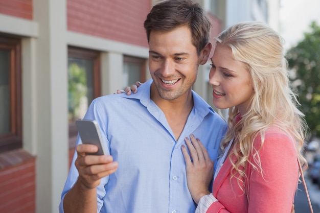 Casal jovem elegante olhando para smartphone