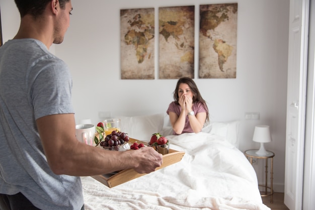 Casal jovem em casa com café da manhã na cama surpresa