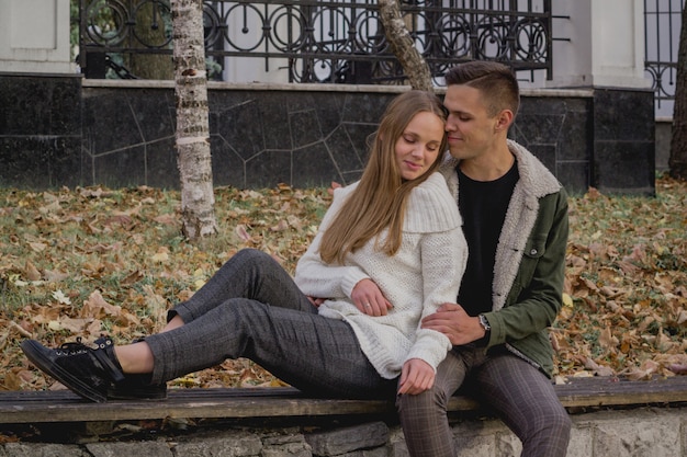 Casal jovem feliz andando em um dia de outono no parque.