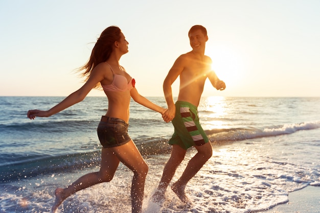 Casal jovem feliz, aproveitando o mar