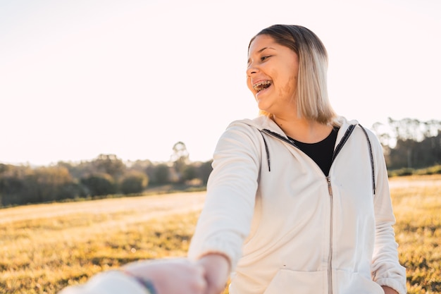 Casal jovem feliz caminhando juntos em um parque de mãos dadas.