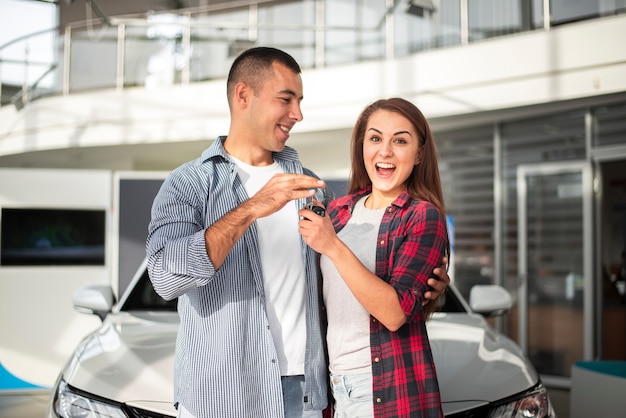 Foto casal jovem feliz com carro novo