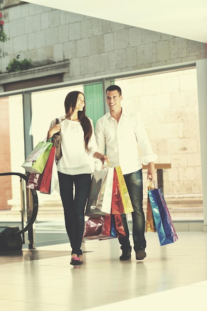 casal jovem feliz com sacos no shopping center