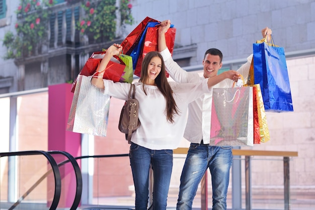 casal jovem feliz com sacos no shopping center