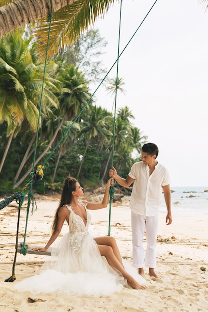Casal jovem feliz comemorando seu casamento na praia