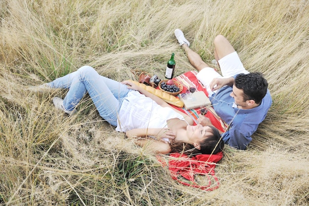 casal jovem feliz desfrutando de piquenique na zona rural no campo e se divertir