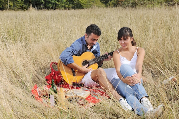 casal jovem feliz desfrutando de piquenique na zona rural no campo e se divertir