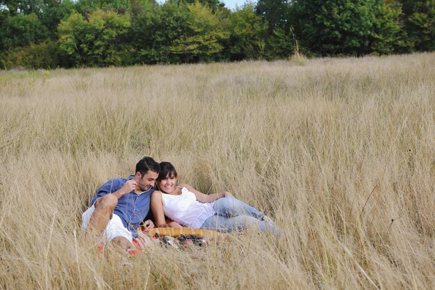 casal jovem feliz desfrutando de piquenique na zona rural no campo e se divertir