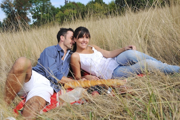 casal jovem feliz desfrutando de piquenique na zona rural no campo e se divertir