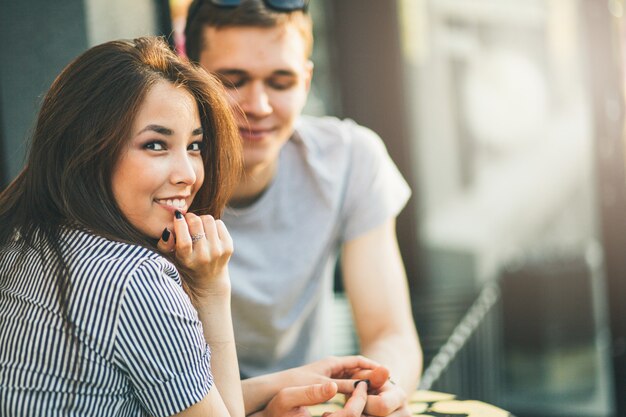 Casal jovem feliz em amigos de adolescentes amor vestidos em estilo casual, sentados juntos