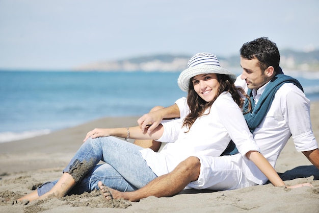 casal jovem feliz em roupas brancas tem recreação romântica e diversão na bela praia de férias