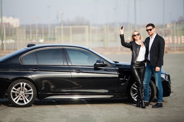 Casal jovem feliz escolhe e comprando um carro novo para a família.