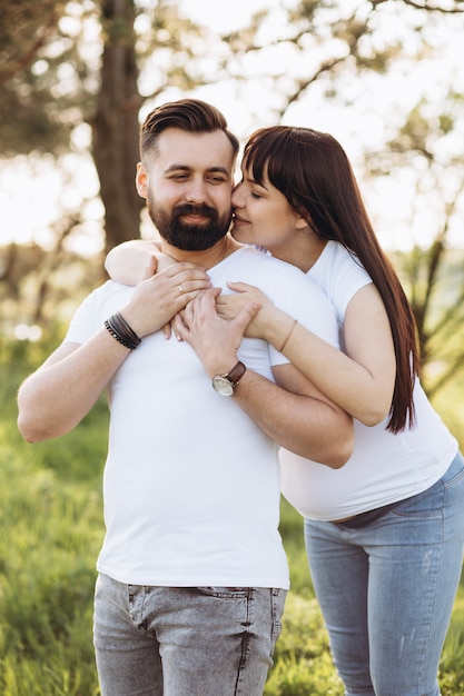 Foto casal jovem feliz esperando bebê no parque de verão