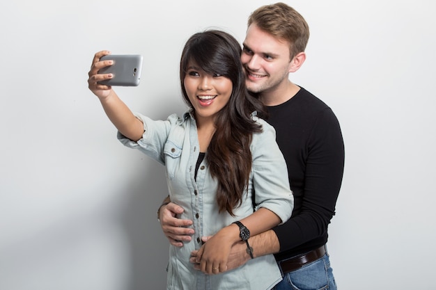 Casal jovem feliz Multiculture, tendo auto-câmera juntos