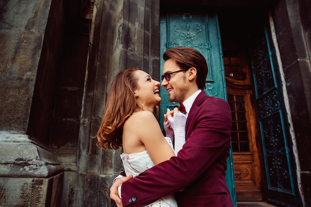 Casal jovem feliz no vestido de casamento na entrada para o antigo