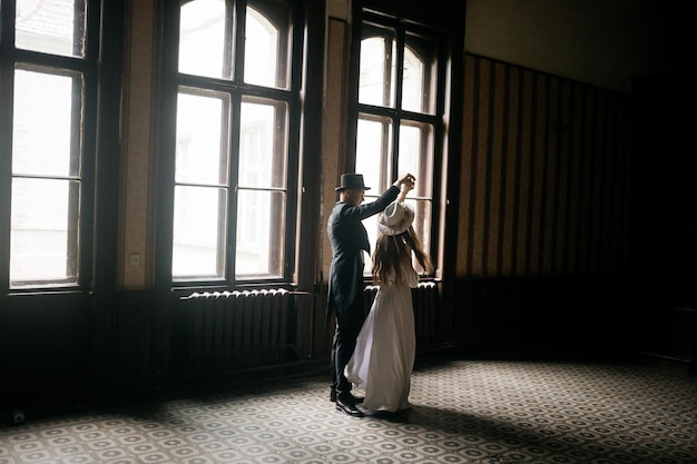 Casal jovem feliz Noivas de chapéu Moça em um vestido de noiva branco e chapéu com um buquê de flores Noivas no castelo Noiva e noivo