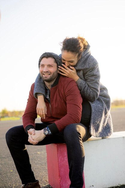 Casal jovem feliz sentado ao ar livre