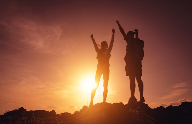 Casal jovem feliz sobe ao topo das montanhas perto do oceano