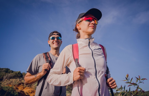 Casal jovem feliz sobe ao topo das montanhas perto do oceano