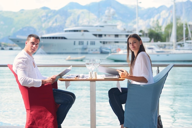 casal jovem feliz tendo lanche no belo restaurante à beira-mar na praia