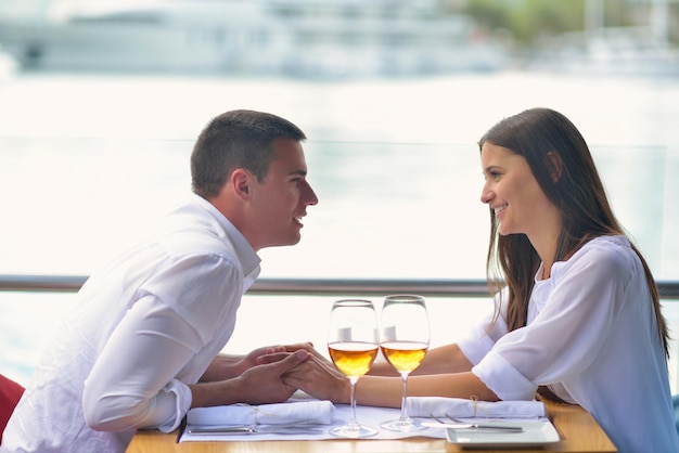 casal jovem feliz tendo lanche no belo restaurante à beira-mar na praia