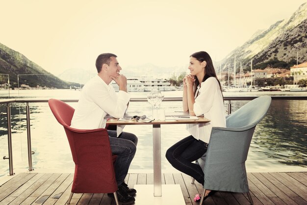 casal jovem feliz tendo lanche no belo restaurante na praia