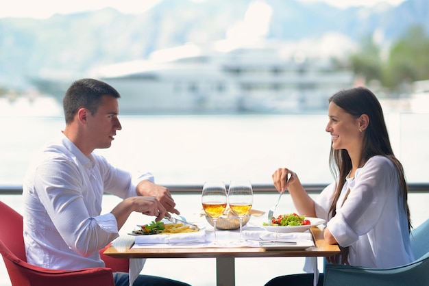 casal jovem feliz tendo lanche no belo restaurante na praia