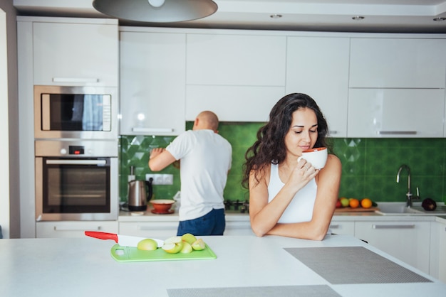 Casal jovem feliz tomando café na cozinha